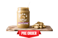 a jar of peanut butter on a wooden cutting board